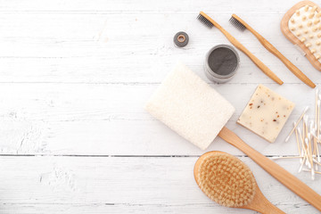 Fototapeta na wymiar Sustainable and eco friendly beauty products, zero plastic lifestyle concept with homemade soap, natural loofah, bamboo toothbrush and foot massager isolated on white wood background with copy space