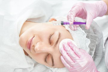 Beautician gives beauty injections to young woman in salon. Mesotherapy, biorevitalization or...