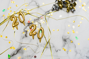 Candles in the shape of numbers 2020 as a symbol of the new year next to christmas shaped sparkler candles fountain on a marble table. top view, flat lay, copyspace