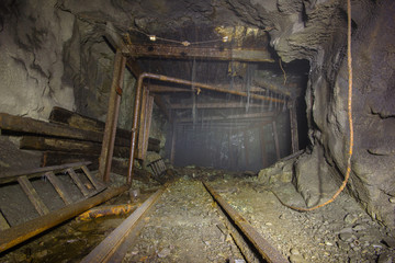 Fototapeta na wymiar Underground gold mine shaft tunnel with fog