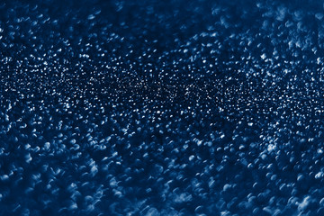 Glowing sparkles on blue color trendy background. Holiday bright brilliant beautiful background, template for blog or designers. Classic Flat lay. New Year 2020