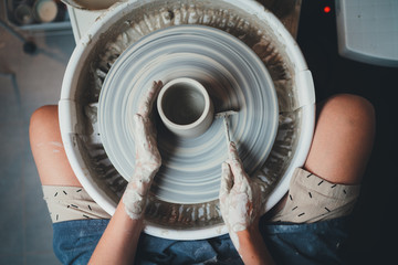 Fototapeta na wymiar Top View Shot of Female Ceramic Artist Working with Clay on Pottery Wheel Makes Shape of Future Vase, Handicraft Creative People Pottery Class Workshop