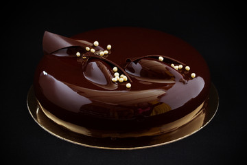 Modern cake covered with chocolate glyassazhem.