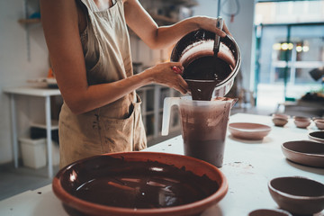 Closeup of Female Hands Glazing Handmade Big Bowl in Modern Pottery Workshop,  Handcraft Creative...