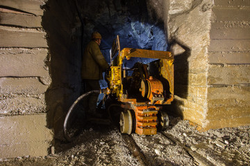 Fototapeta na wymiar Underground gold mine shaft tunnel drift with loading machine eimco