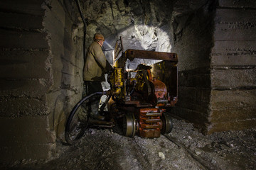 Fototapeta na wymiar Underground gold mine shaft tunnel drift with loading machine eimco