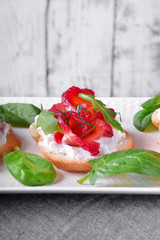 Trout Gravlax on the slice of white bread with ricotta topped with greenery against the white background. Nordic cuisine meal