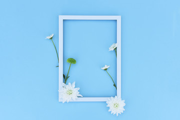 White frame with a flower arrangement on a blue background.