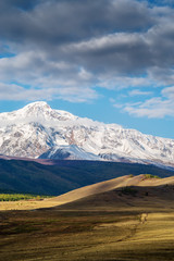 A fenced pasture in the Kurai steppe, the North Chuysky ridge on the horizon. Autumn in the Altai mountains. Russia