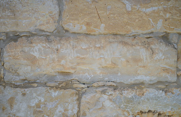 A masonry wall of multicolored stones or blocks