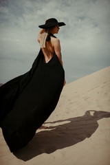 woman portrait in black dress in desert 