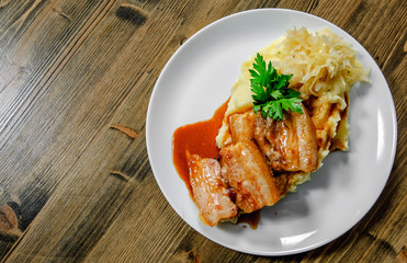 Fried pork chop, mashed potato and vegetable salad in plate on a wooden background.
