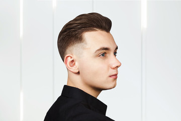 Young guy with a pompadour hairstyle dressed in black shirt with a serious face