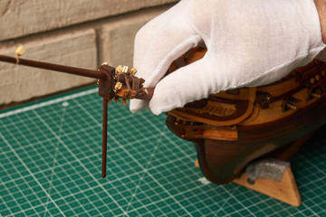 Installing the bowsprit on the ship model. Assembly of ship model from wood