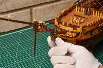 Installing the figurehead on the ship model. Assembly of ship model from wood