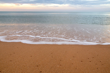 Bubbles of sea waves on the beach with sand.Sea breeze blowing waves to the beach.There are feeling fresh and succulent for this image.Can use for add text and abstract background.
