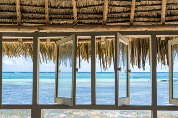 Open windows of thatched roof veranda overlooking the turquoise ocean on the island of Zanzibar, Tanzania, Africa