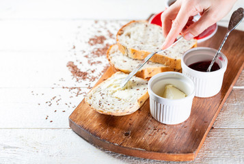 Sliced toast bread with butter on wooden cutting board. Morning breakfast with coffee, butter and toasts.
