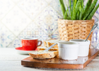 Sliced toast bread with butter on wooden cutting board. Morning breakfast with coffee, butter and toasts.