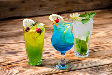 green fairy cocktails with lemon and absinthe, a blue lagoon and mojito in a bar