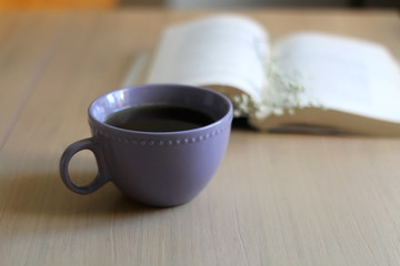 Cup of tea, book and gypsophila flowers on wooden table. Selective focus.