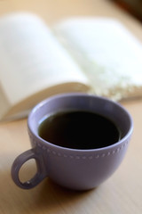 Cup of tea, book and gypsophila flowers on wooden table. Selective focus.