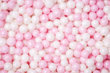 Pastel pink and white background. Sweet sugar balls. Sprinkles sugar texture. Bokeh, blurred background