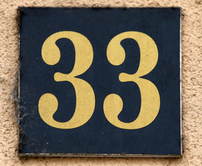 Vintage grunge square metal rusty plate of number of street address with number. Close up, brand. 33