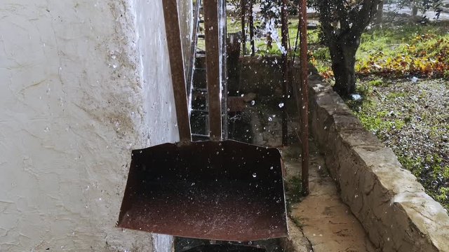 Slow motion close-up of a vintage watermill in motion.