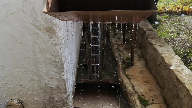 Close-up of an old watermill. View of the old rustic buckets dripping water as they rotate.