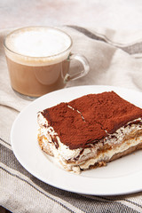 Tasty piece of tiramisu with cup of coffee. Homemade tiramisu with cappuccino.