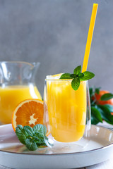 Natural freshly squeezed orange juice with ice and mint in a glass © Eleonora