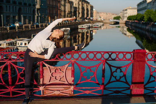 Young woman doing backbend exercise outdoor in city center