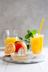 Natural freshly squeezed orange juice with ice and mint in a glass