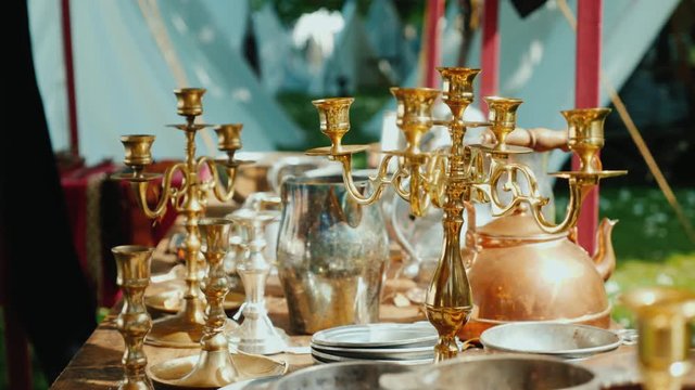 Antique dishes, candlesticks and other items in an antique outdoor tent