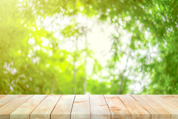Wood board on the bamboo garden defocus blur background in the noon with orange - yellow sunlight...
