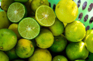 Many lemons in the basket Both green and yellow