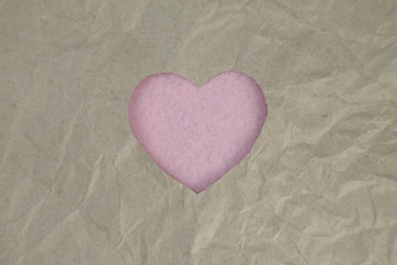 Pink felt heart on craft paper. Crumpled paper texture. Valentine's day stock photo for web, print and wallpaper.With empty space for text.