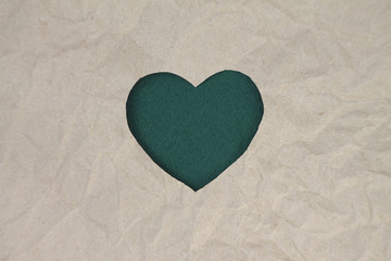 Green felt heart on craft paper. Crumpled paper texture. Valentine's day stock photo for web, print and wallpaper.With empty space for text.