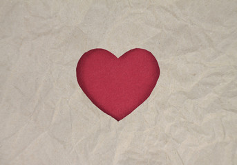 Fototapeta premium Red felt heart on craft paper. Crumpled paper texture. Valentine's day stock photo for web, print and wallpaper.With empty space for text.