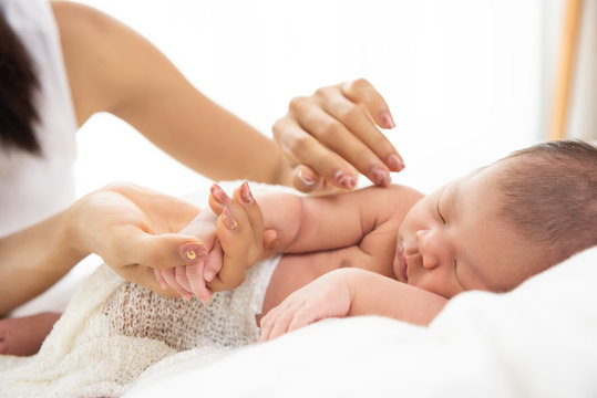 Newborn asia baby holding mother's hand
