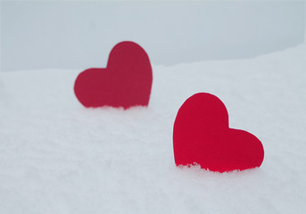 Fototapeta premium Two red felt hearts on the snow. Handmade for the celebration and holiday. Stock Photography for Valentine's Day with empty space for your text. For web, print, cards, invitations and wallpapers.