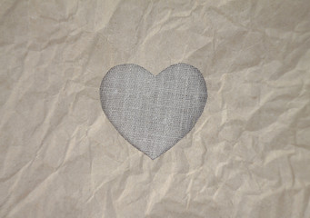 Flax heart on craft paper. Crumpled paper texture. Valentine's day stock photo for web, print and wallpaper. With empty space for text.