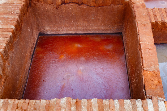 Different old stone vats with red dye for leather at Tannery of Tetouan Medina. Northern Morocco.