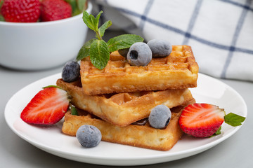 Belgian waffles with strawberries and blueberries for Breakfast.