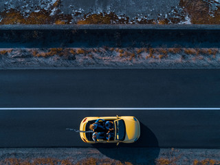 The four friends traveling by yellow cabriolet
