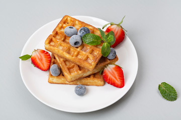 Belgian waffles with strawberries and blueberries for Breakfast.