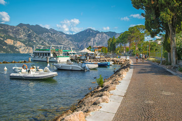 Fototapeta na wymiar Malcesine - The promenade of Lago di Garda with the boats in the morning.