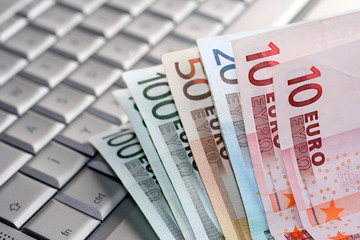 Euro banknotes on a silver keyboard