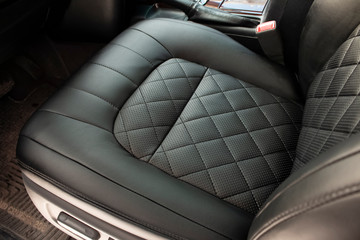 Front, black leather driver's seat embroidered with diamond shapes
